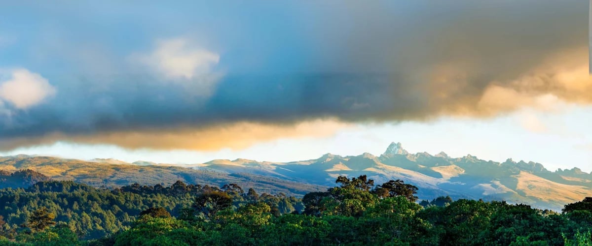 Mountain ridges rising above forested highlands beneath low clouds